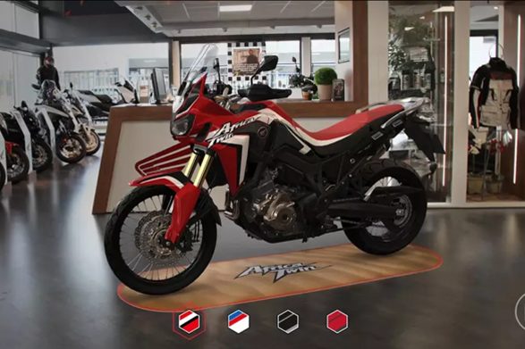 The app placing a red Africa Twin on a showroom floor, with colour choices along the bottom